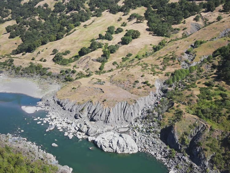 This large, active earthflow displaced the railway prism and buried the railgrade and tracks. Re-routing upslope to a more stable location is recommended.