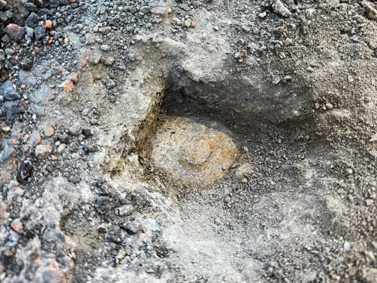 A layer of broken asphalt was removed to find this monument.