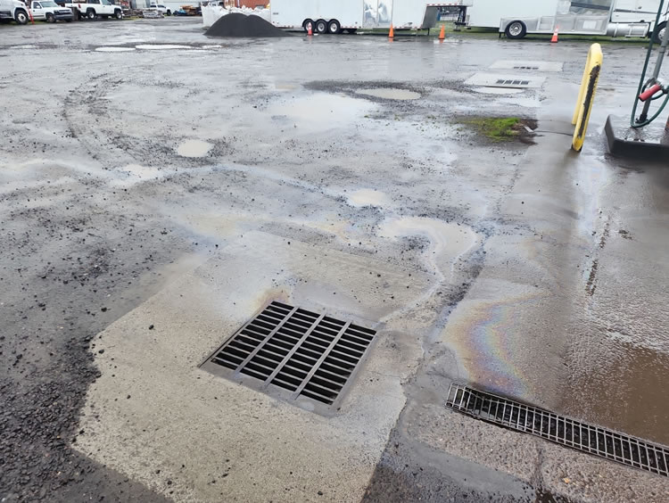 Environmental field staff map surface water flow and drainage to assess potential contamination pathways and mitigation points.
